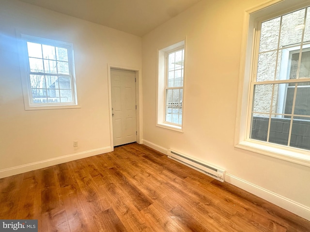 unfurnished room featuring light hardwood / wood-style flooring and baseboard heating