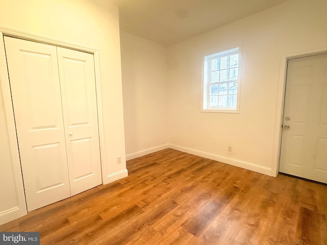 unfurnished bedroom with a closet and light wood-type flooring