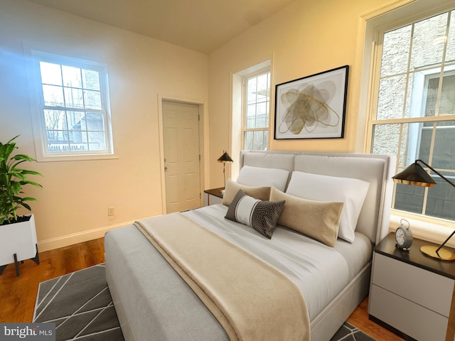 bedroom featuring dark hardwood / wood-style floors and multiple windows