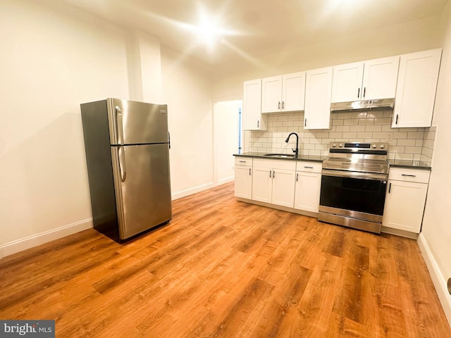 kitchen featuring sink, backsplash, white cabinets, light hardwood / wood-style floors, and stainless steel appliances