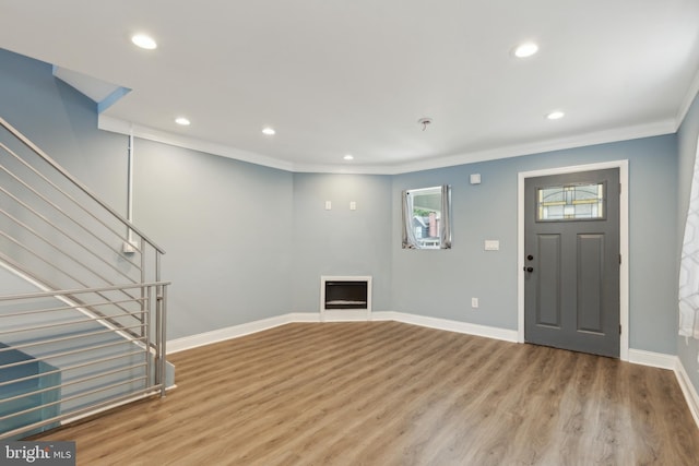 entryway featuring crown molding and light wood-type flooring