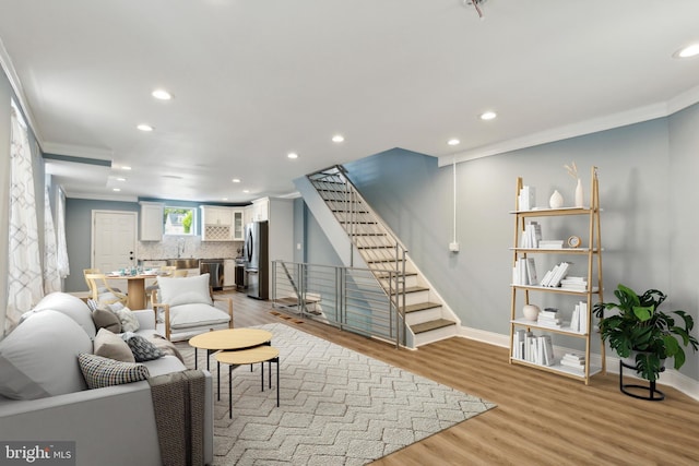 living room with crown molding and light hardwood / wood-style floors