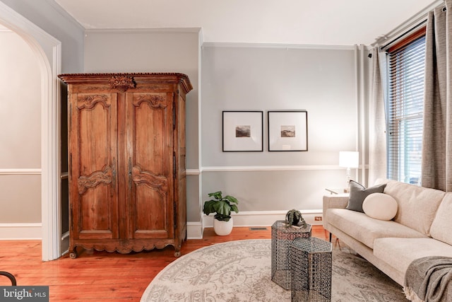 living area featuring ornamental molding and hardwood / wood-style floors