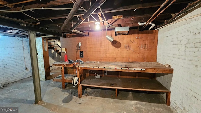 basement with a workshop area and brick wall