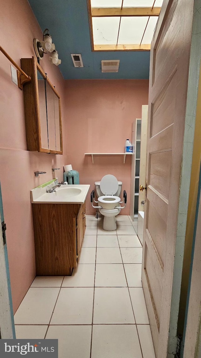 bathroom featuring vanity, tile patterned floors, and toilet