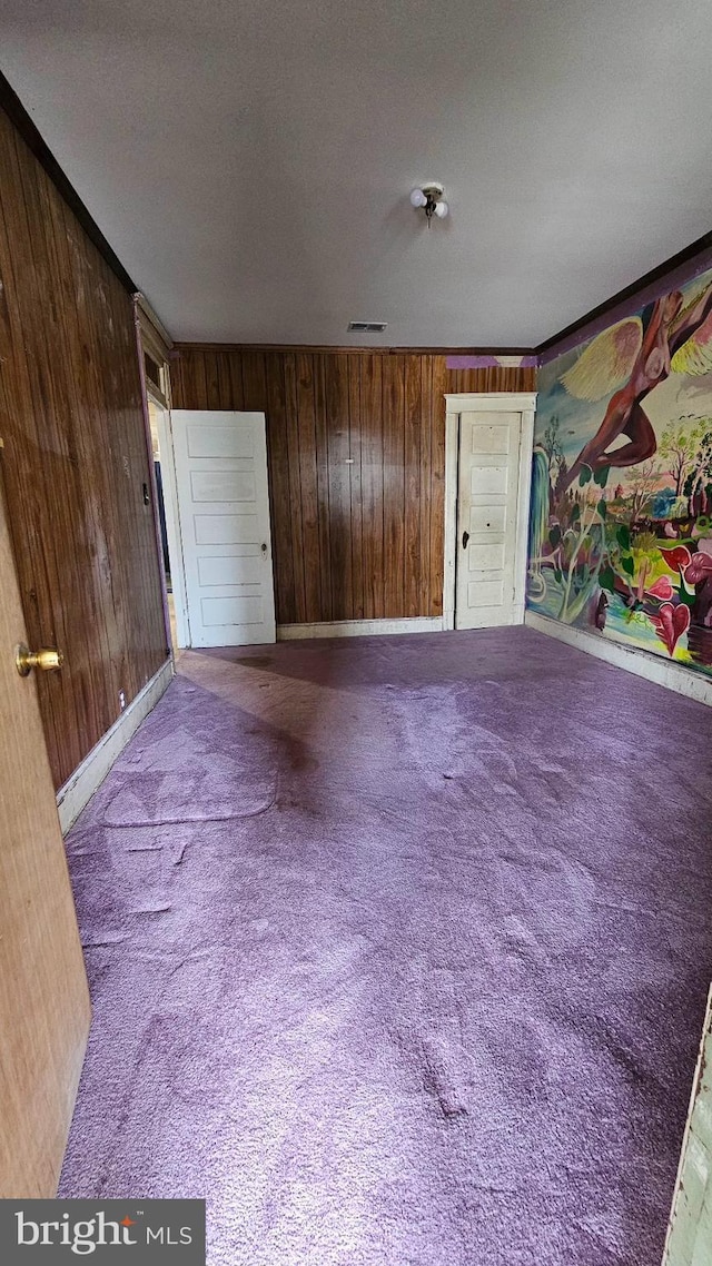 interior space featuring carpet flooring and wood walls