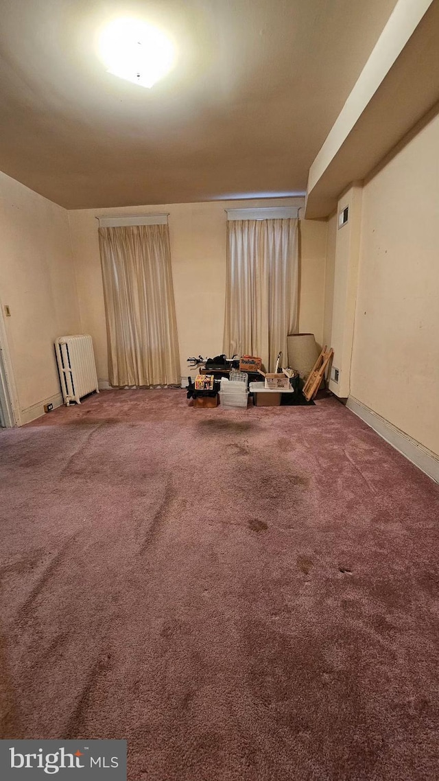 unfurnished room with carpet floors and radiator heating unit