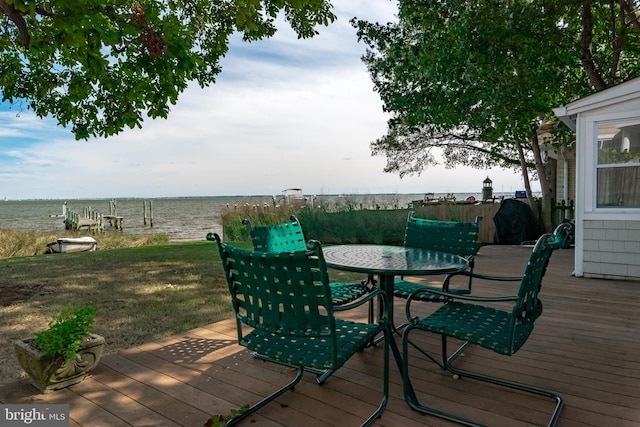 deck featuring outdoor dining space and a water view