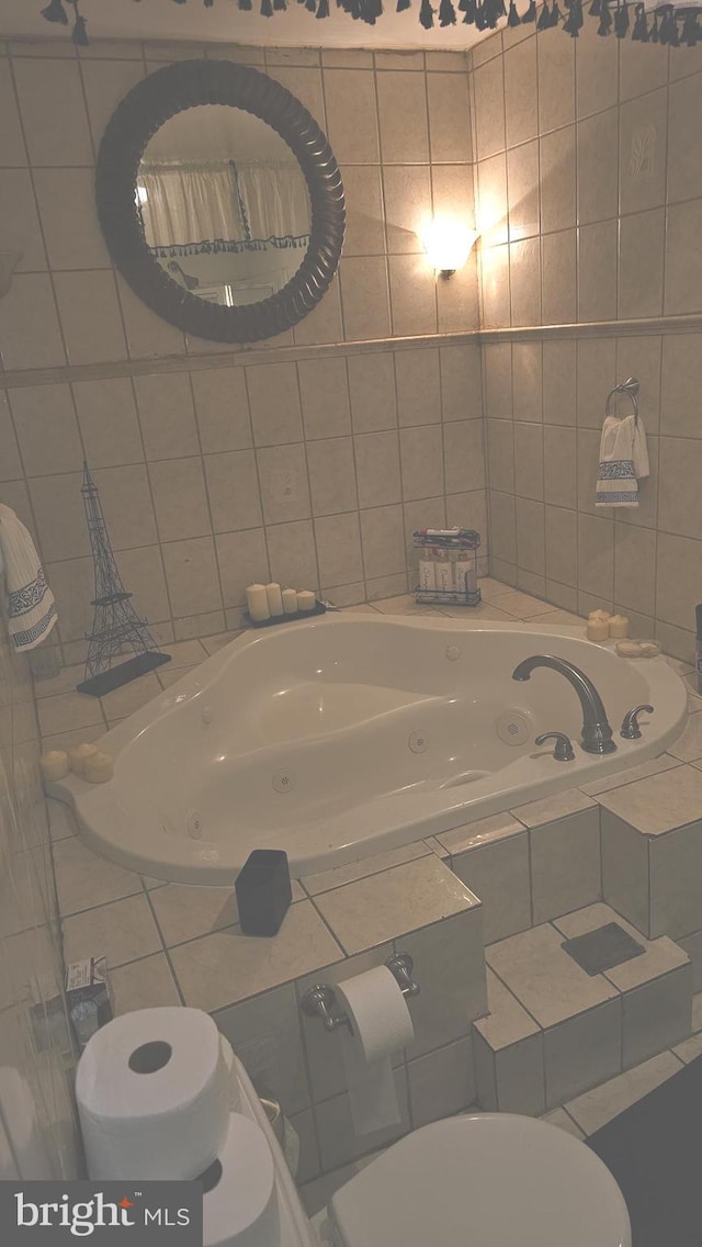 bathroom featuring toilet, tiled bath, and tile walls