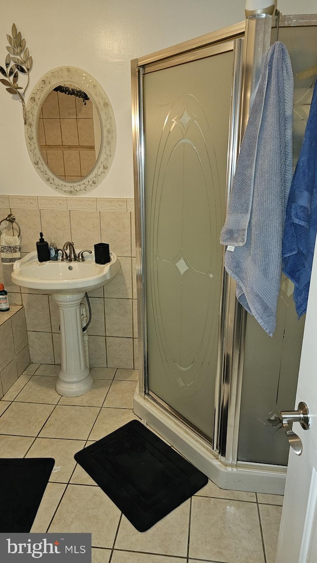 bathroom with an enclosed shower, tile walls, and tile patterned floors