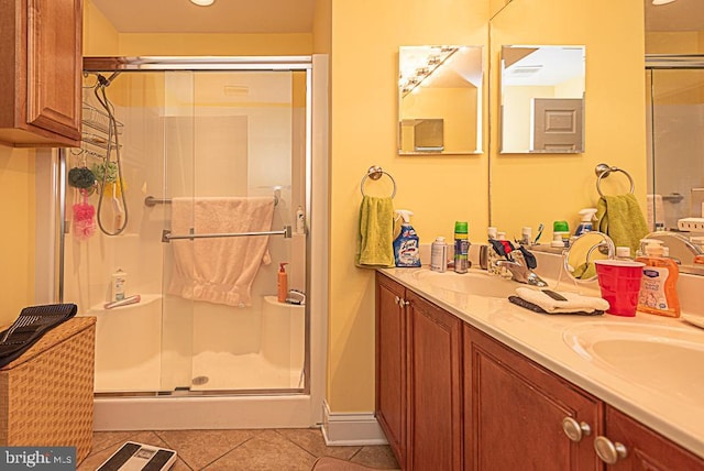 bathroom with tile patterned floors, a shower with door, and vanity