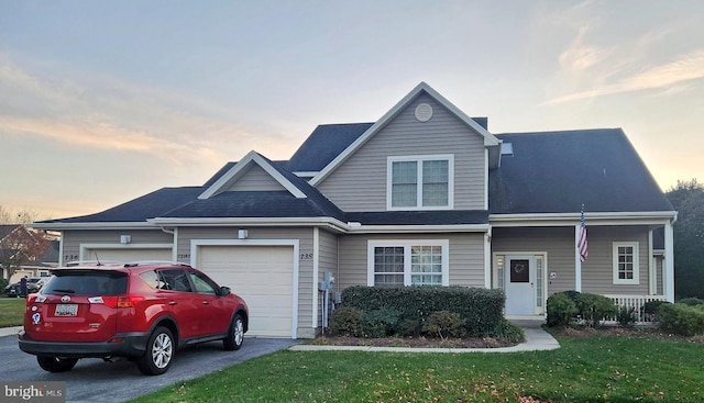 view of front of property featuring a yard and a garage