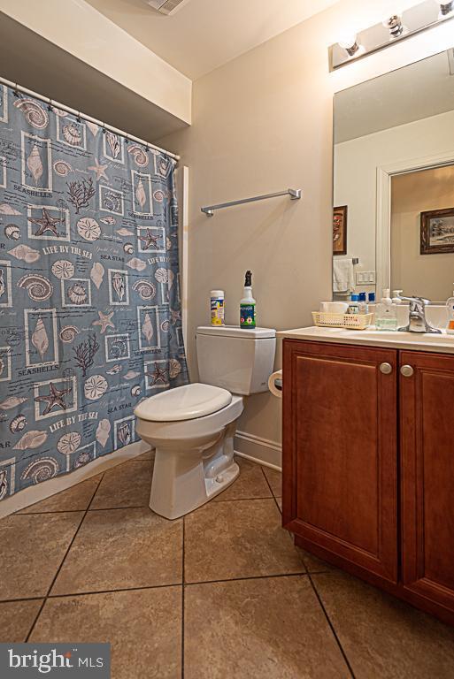 bathroom featuring vanity, tile patterned floors, and toilet