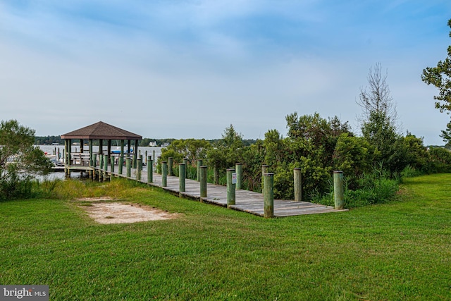 dock area featuring a water view and a lawn