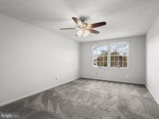 spare room with a textured ceiling, carpet, a ceiling fan, and baseboards