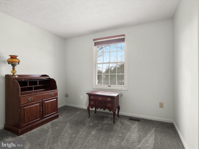 living area with baseboards, visible vents, dark carpet, and a textured ceiling