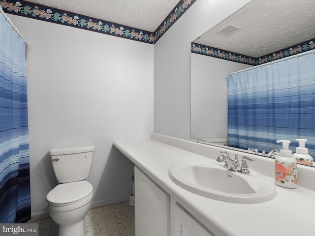 bathroom featuring baseboards, visible vents, toilet, a textured ceiling, and vanity