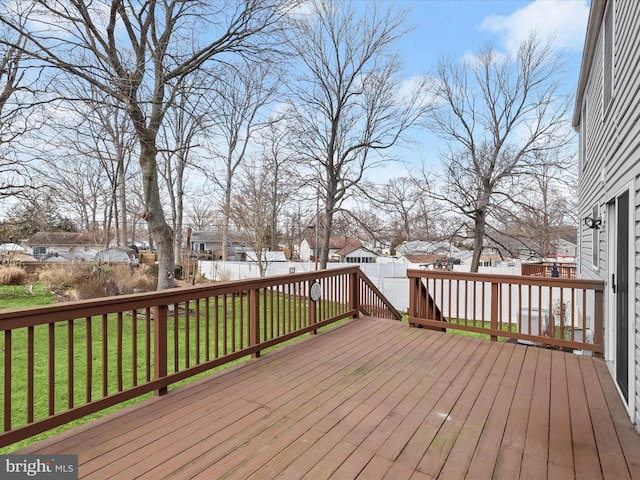 deck featuring a residential view, fence, and a yard