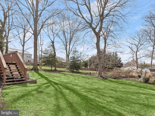 view of yard with stairs and fence