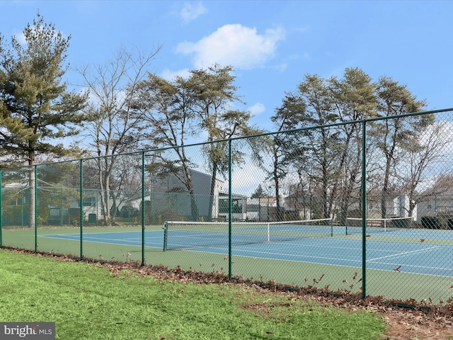 view of sport court with a yard and fence