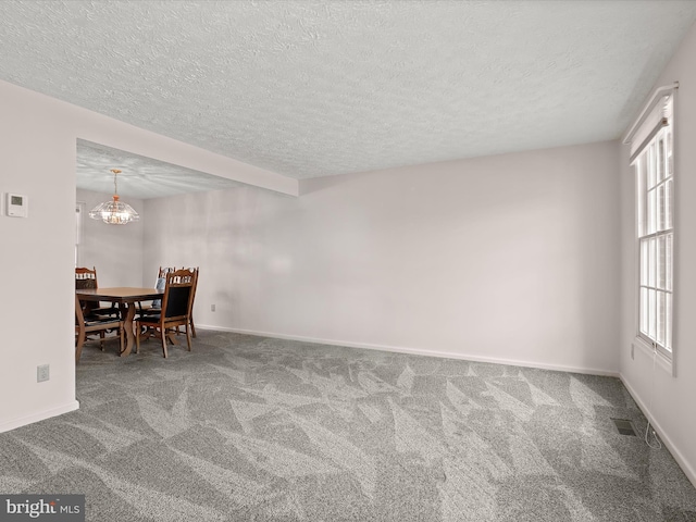 dining room featuring carpet, a textured ceiling, and baseboards