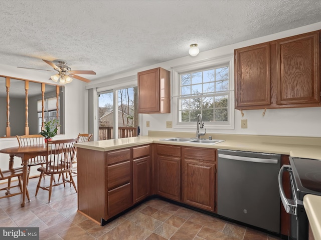 kitchen featuring electric range oven, a peninsula, a sink, light countertops, and dishwasher