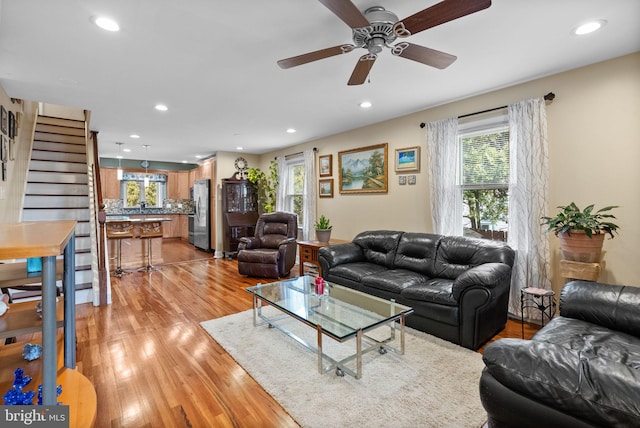 living room featuring ceiling fan, plenty of natural light, and light hardwood / wood-style flooring