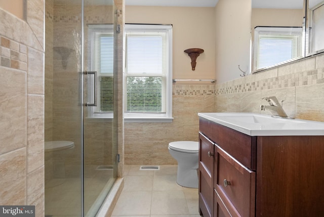 bathroom featuring vanity, plenty of natural light, tile walls, and walk in shower