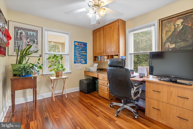 home office featuring dark hardwood / wood-style flooring and ceiling fan