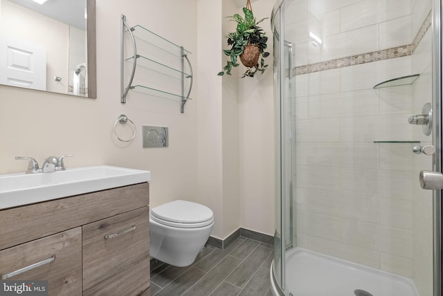 bathroom featuring vanity, a shower with shower door, and toilet