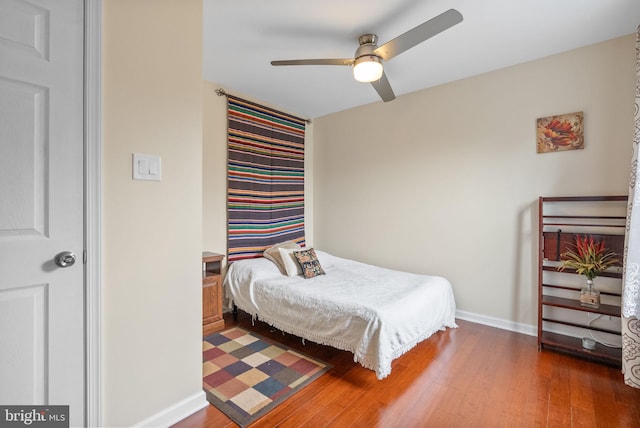 bedroom with dark hardwood / wood-style floors and ceiling fan