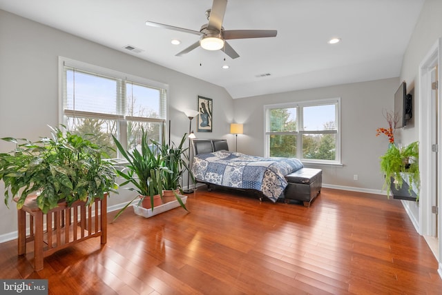 bedroom with multiple windows, wood-type flooring, and ceiling fan