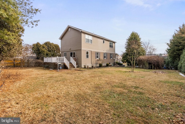 back of property featuring a yard and a deck