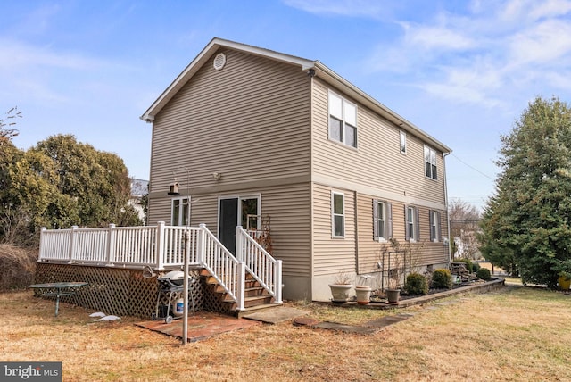 back of house with a wooden deck and a yard