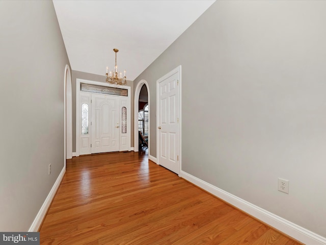 foyer with hardwood / wood-style flooring and a chandelier