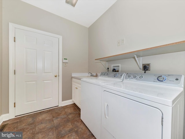 washroom with sink, cabinets, and washing machine and clothes dryer