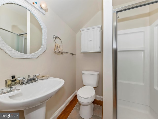 bathroom with vaulted ceiling, wood-type flooring, sink, walk in shower, and toilet