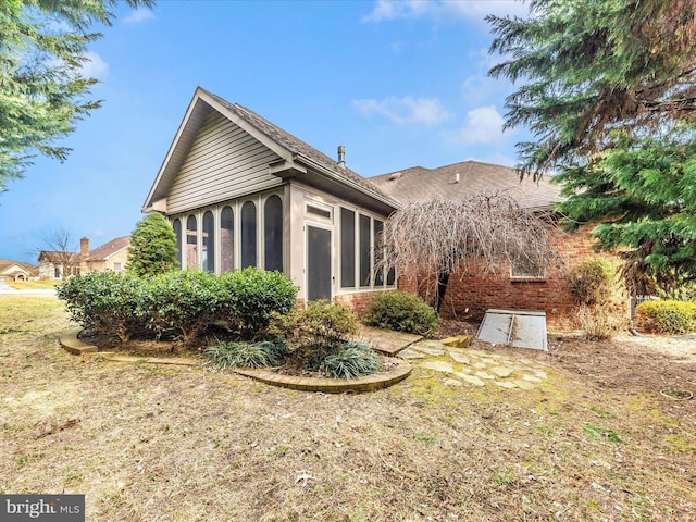 view of home's exterior with a sunroom