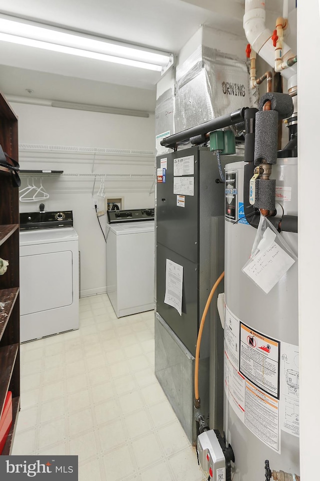 utility room with water heater and washer and dryer