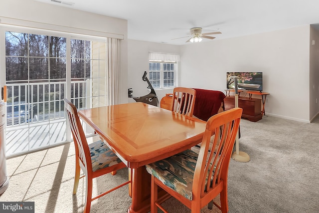 dining space featuring light carpet and ceiling fan