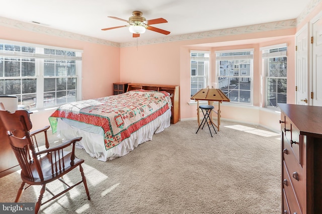 bedroom featuring ceiling fan, carpet floors, and multiple windows