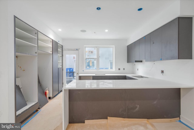 kitchen with black electric stovetop and kitchen peninsula