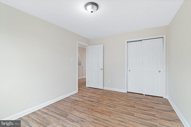 unfurnished bedroom featuring a closet and light wood-type flooring