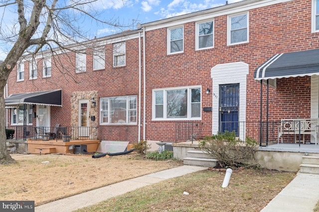 townhome / multi-family property featuring a front lawn