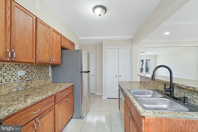 kitchen with light tile patterned flooring, sink, appliances with stainless steel finishes, an island with sink, and backsplash