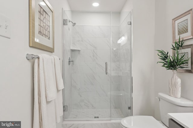 bathroom with an enclosed shower, vanity, and toilet