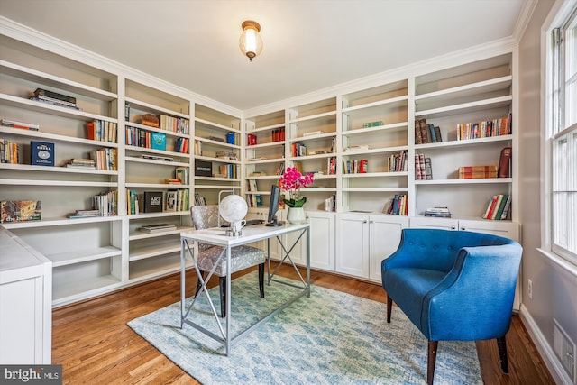 home office featuring visible vents, ornamental molding, and wood finished floors