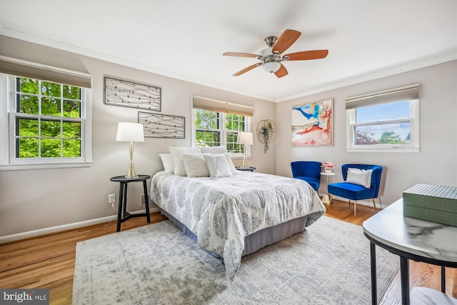 bedroom featuring crown molding, a ceiling fan, baseboards, and wood finished floors