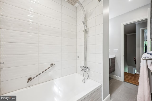 bathroom featuring tile patterned flooring, washtub / shower combination, baseboards, and vanity