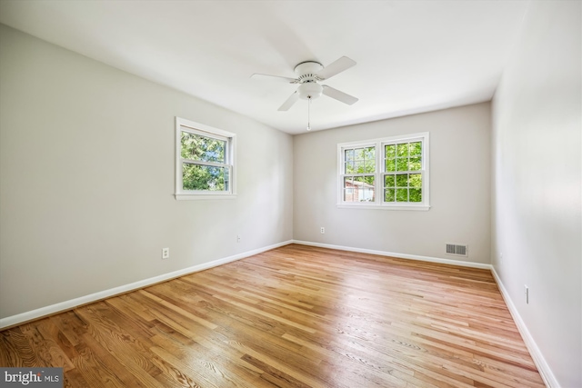 unfurnished room featuring baseboards, a ceiling fan, light wood-type flooring, and visible vents
